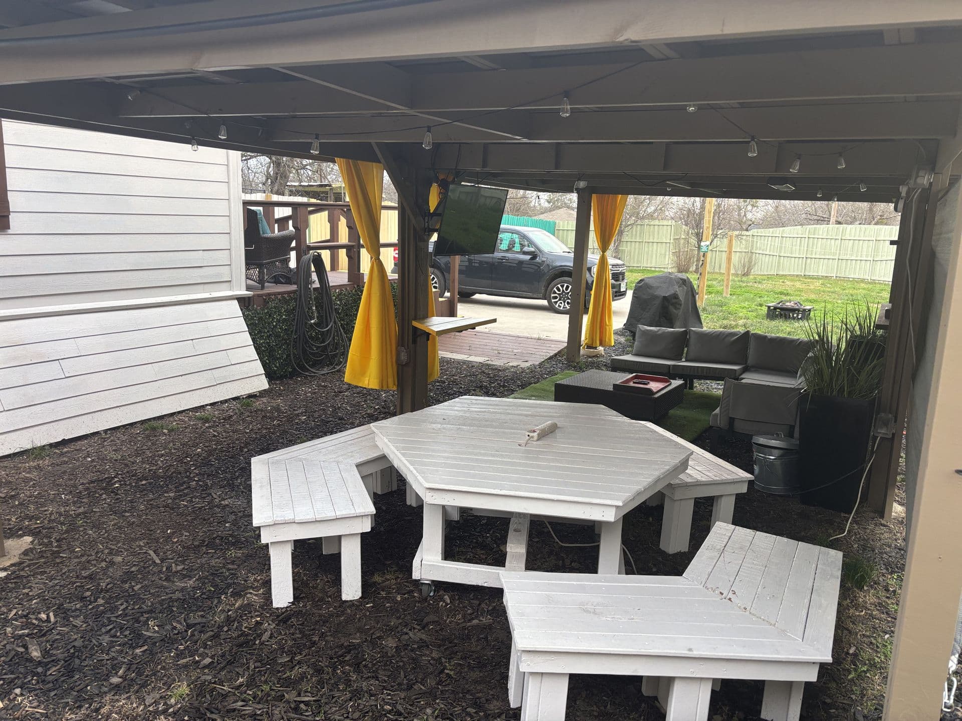 Covered patio with hexagon picnic table and string lights